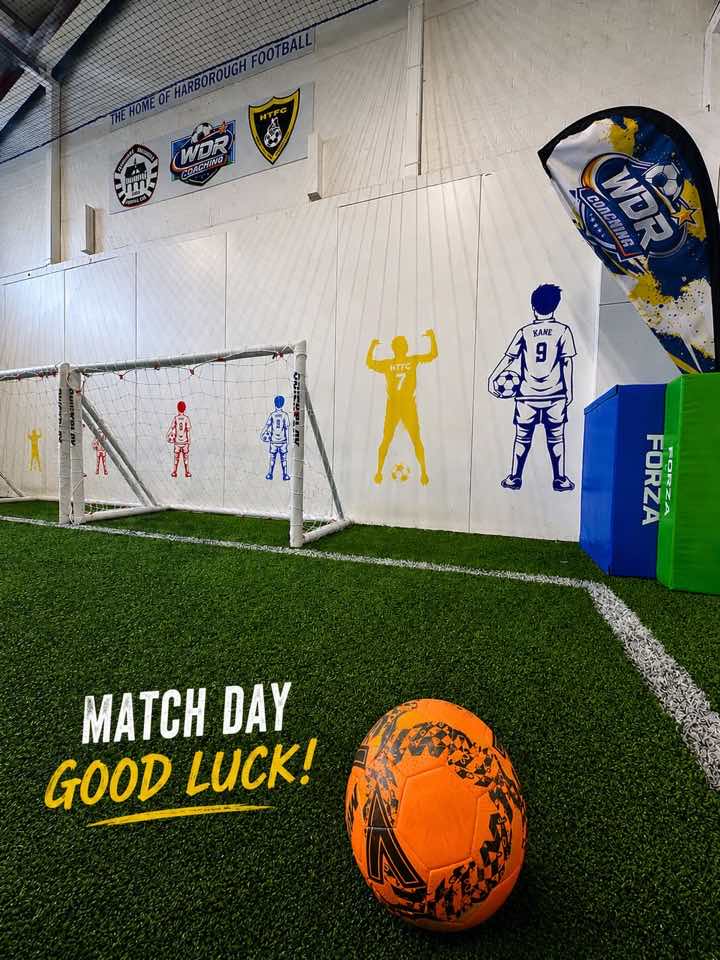 The WDR Coaching feather flag beside the arena wall vinyls and goals
