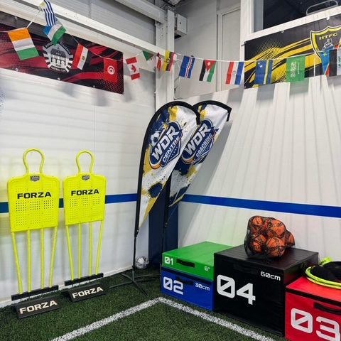 Training equipment at the side of the pitch — FORZA free-kick mannequins, plyometric boxes and a bag of footballs