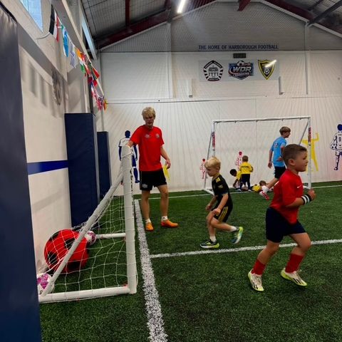 A coaching session under way on the indoor astro, with children playing towards the goal