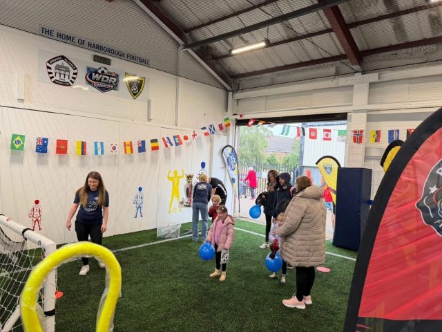 A fun day in the arena — an inflatable obstacle course on the astro with children and parents around it