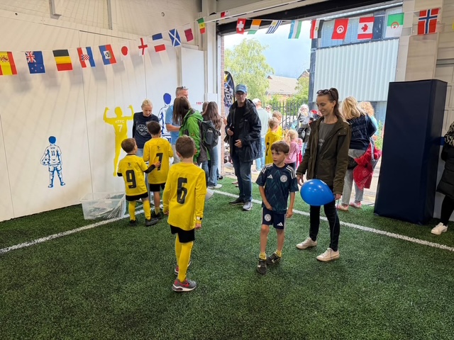 Families and children in Harborough Town kit at an open day in the arena
