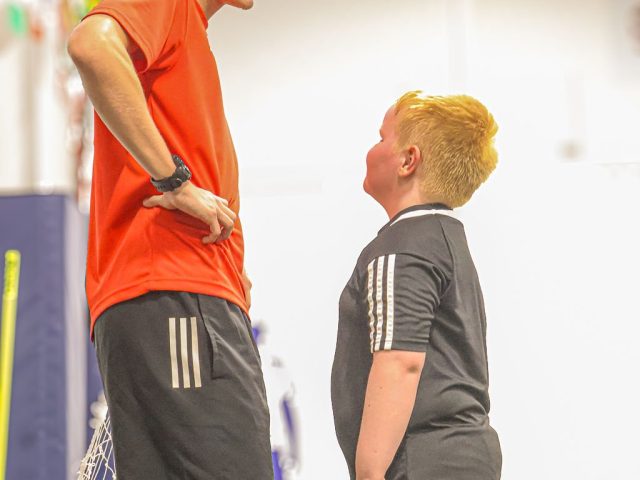 A coach and a young player stood face to face on the astro, both grinning